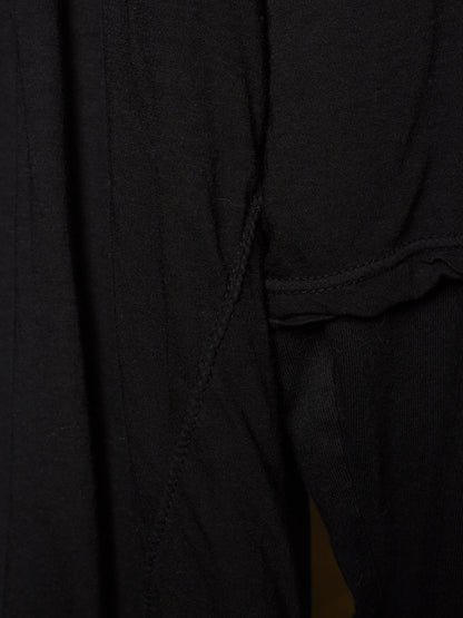 Close-up detail of a black ribbed knit garment, showing the texture of the fabric and a seam.