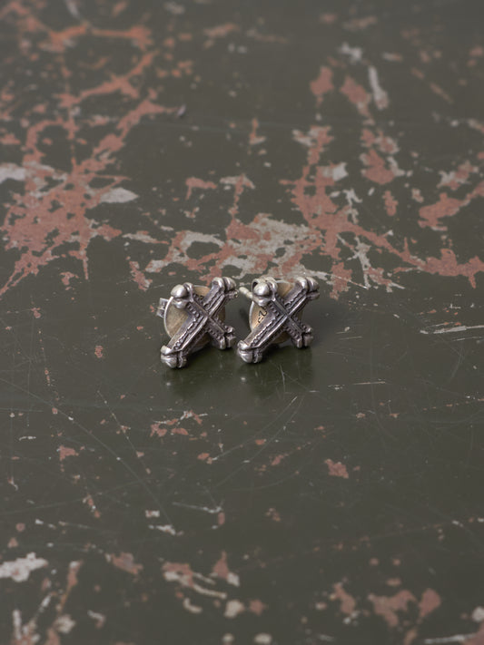 Silver earring on a textured dark surface