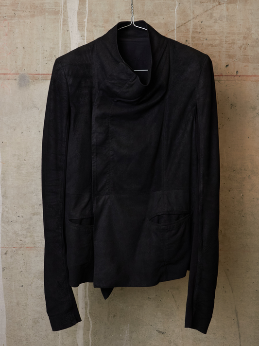 Black jacket hanging on a textured beige wall