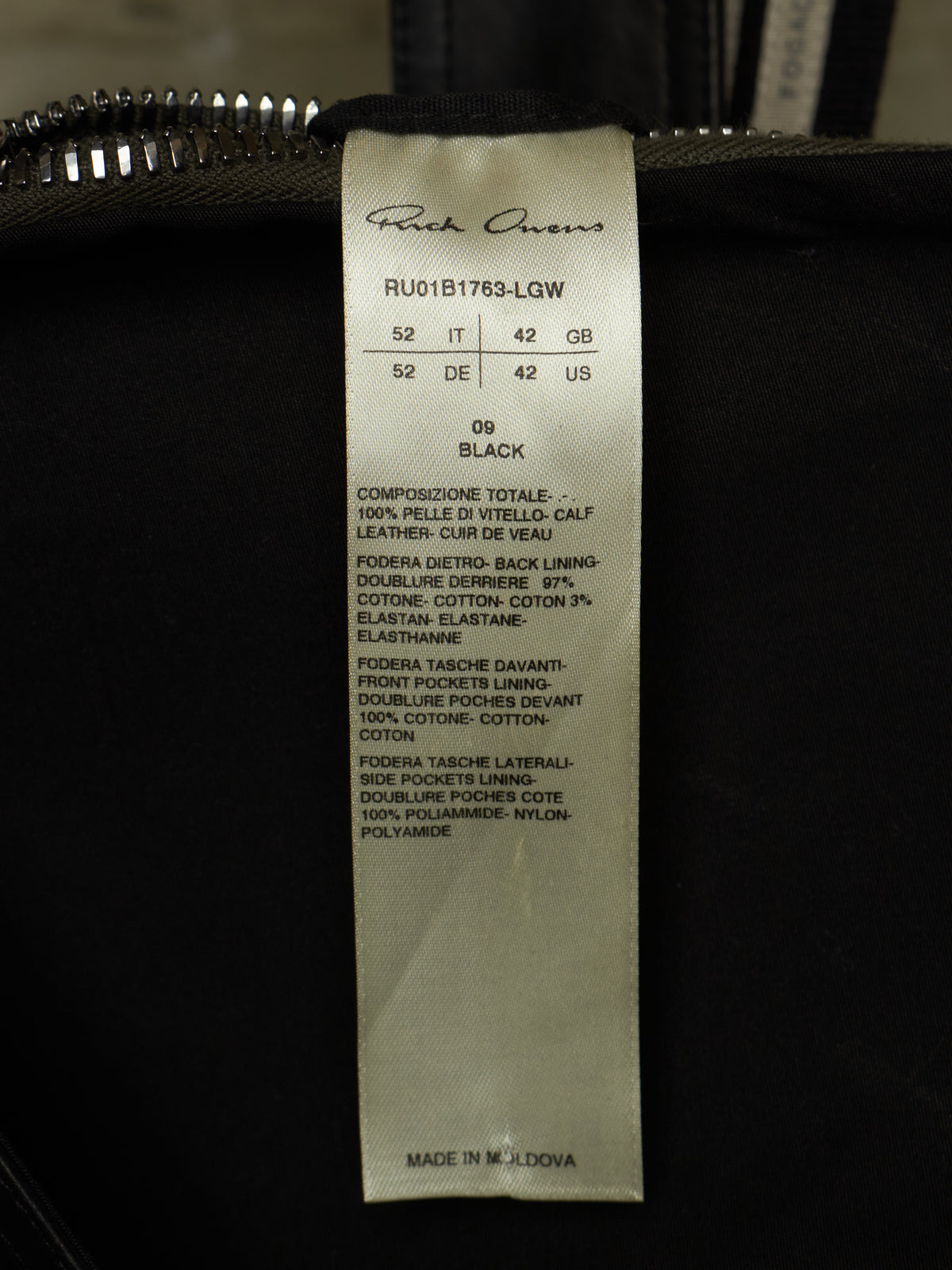 A close-up of a black garment's interior tag showing the brand 'Rick Owens' and size information for a black shoe.