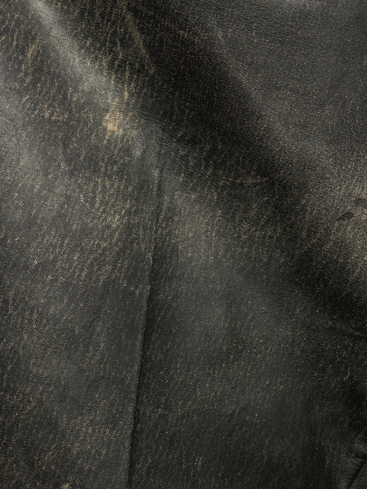 A close-up of dark textured leather with a subtle sheen and visible grain, filling the entire frame.