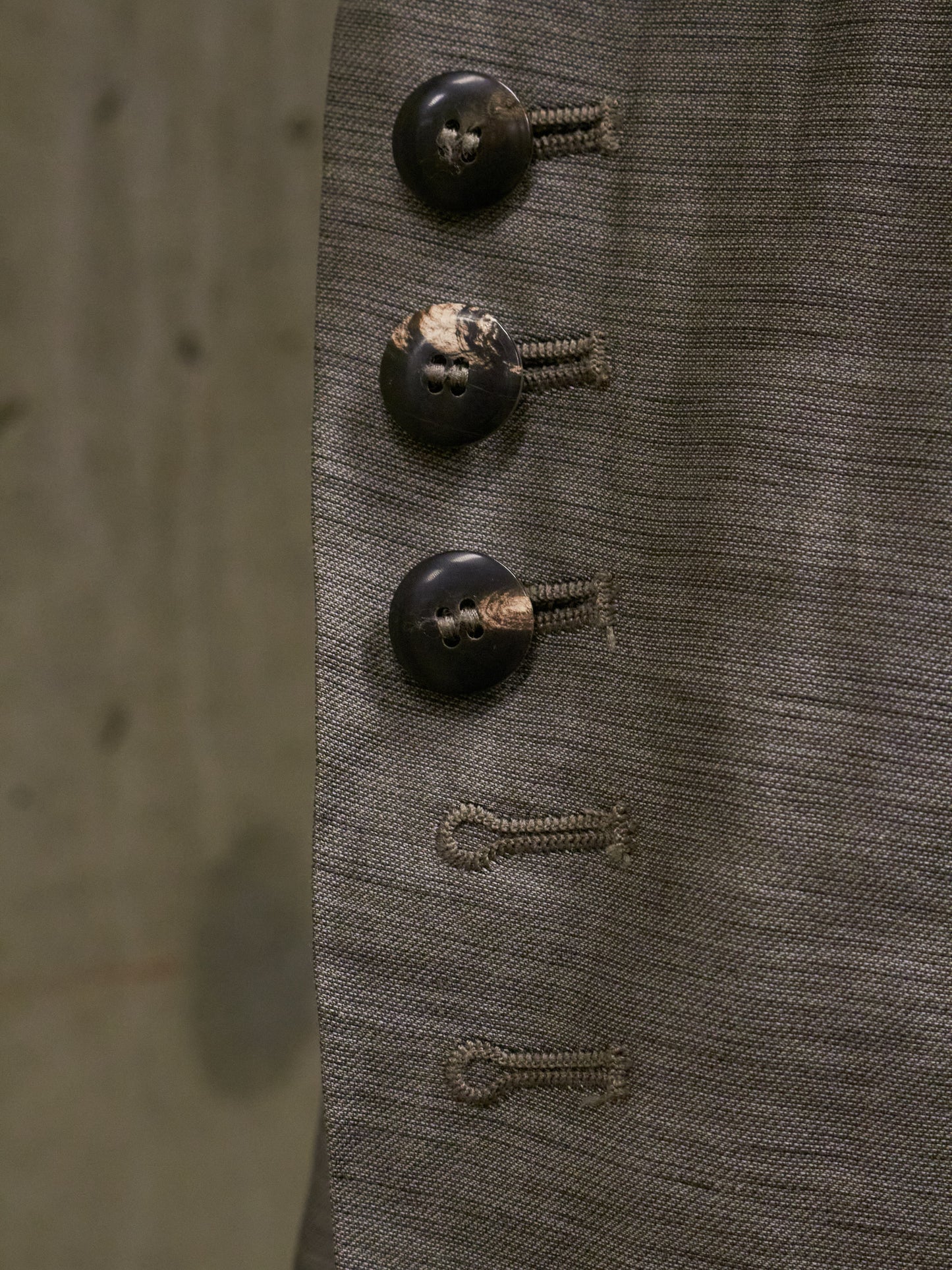 Close-up of three vintage buttons on a textured fabric background