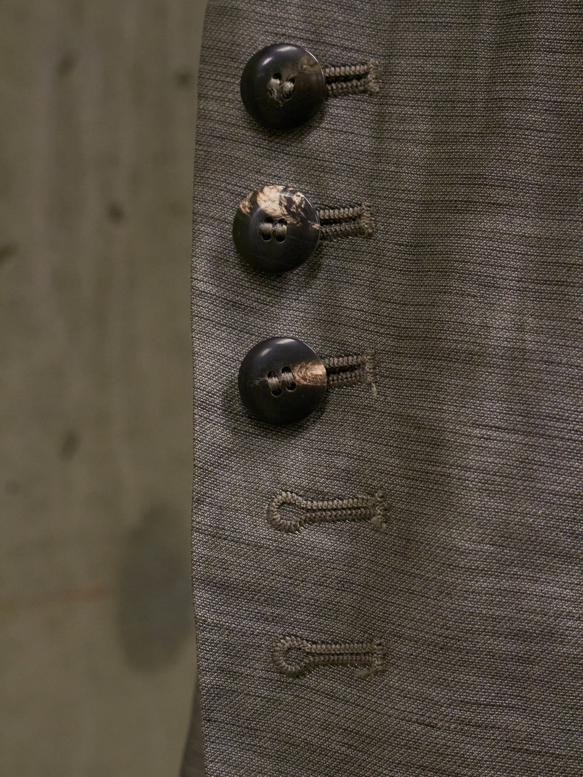 Close-up of three vintage buttons on a textured fabric background