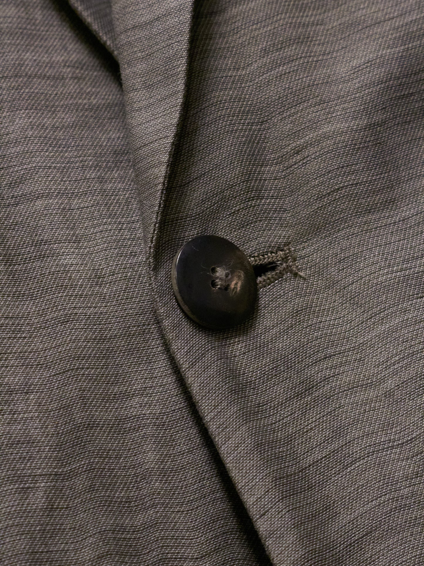 Close-up of a gray textured fabric with a button