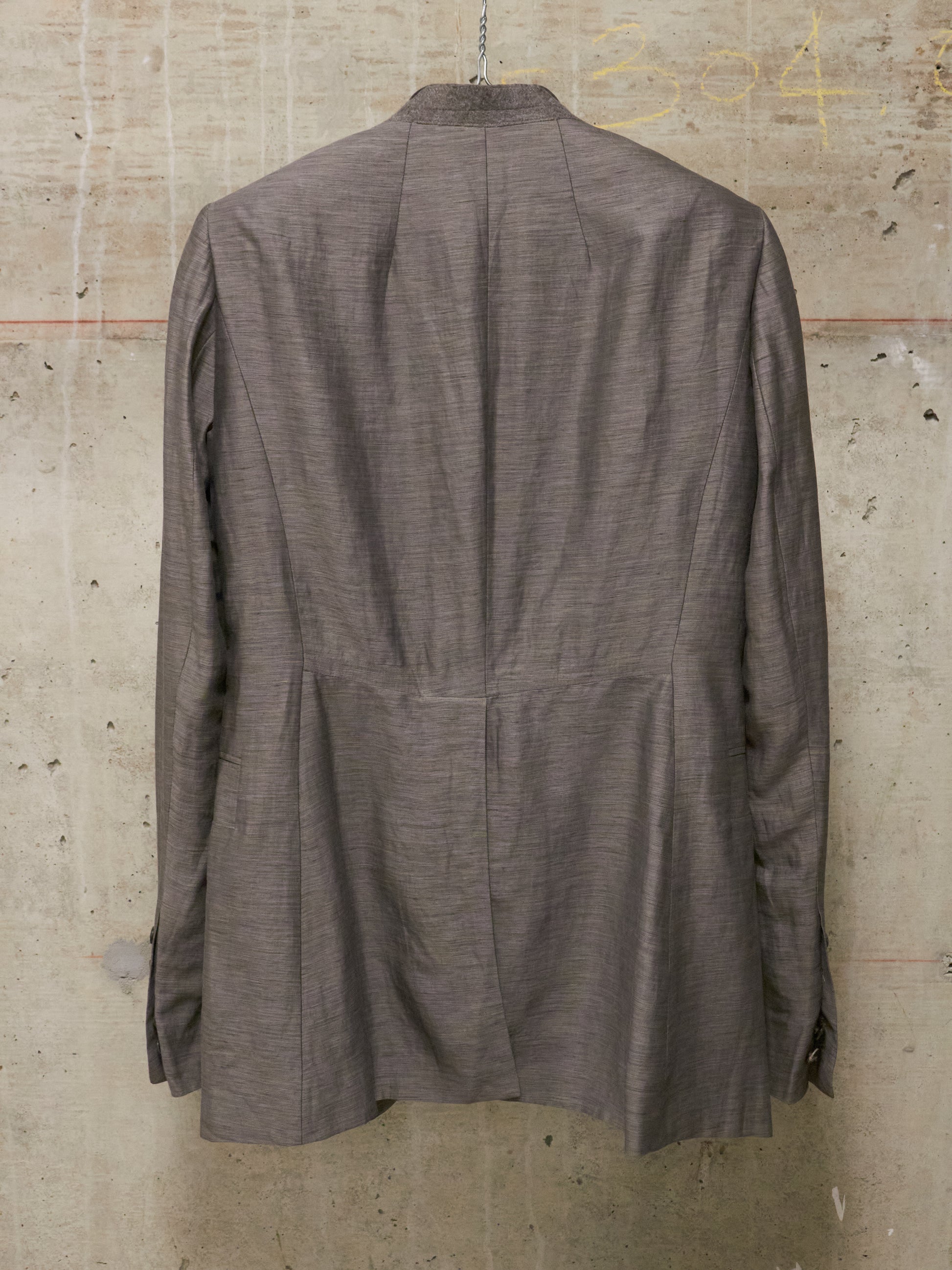 Brown jacket hanging on a textured wall
