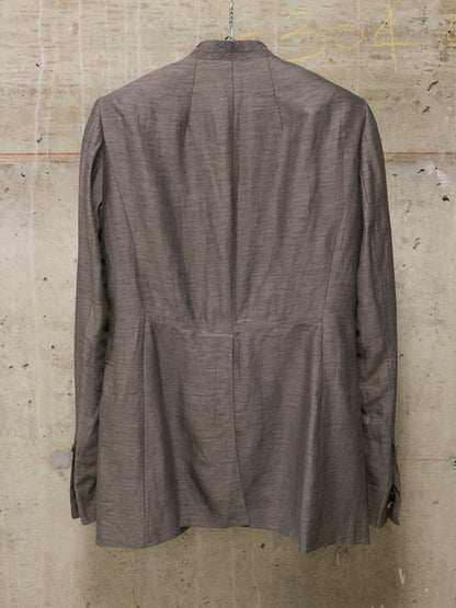 Brown jacket hanging on a textured wall
