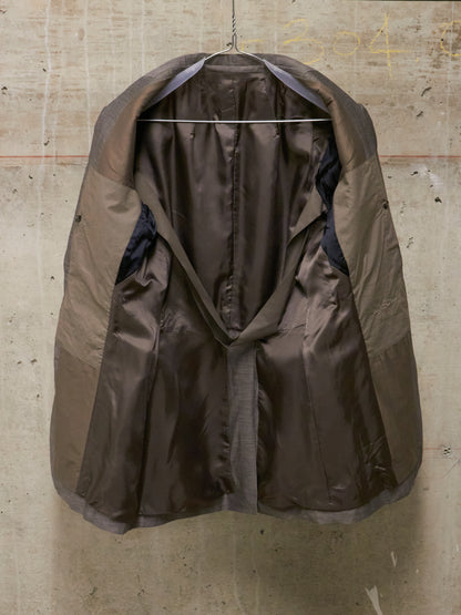 Brown raincoat hanging on a textured wall