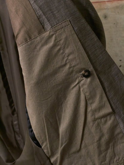 Close-up of a brown jacket with a button on a textured surface