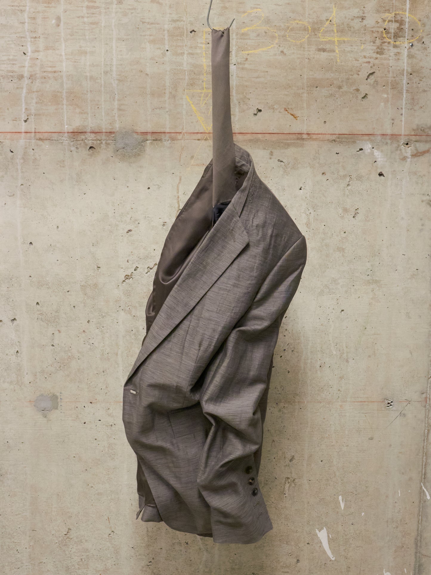 Brown jacket hanging on a textured wall