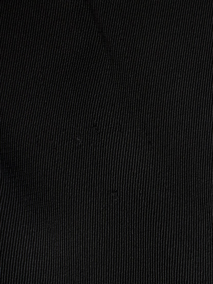 A close-up of black fabric with a fine vertical ribbed texture.