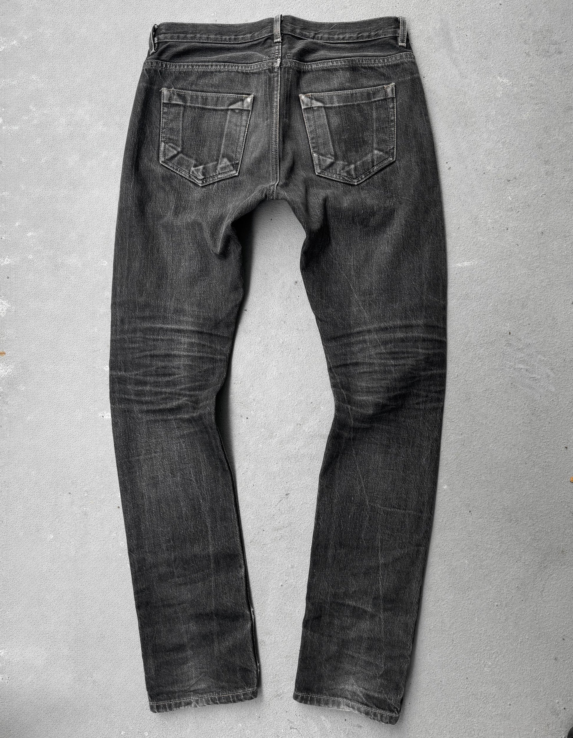 Black jeans on a gray concrete floor