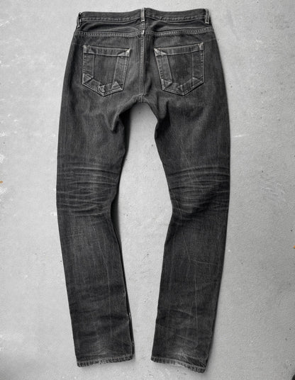 Black jeans on a gray concrete floor