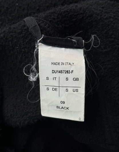 Clothing tag on a black fabric background with 'Made in Italy' text.