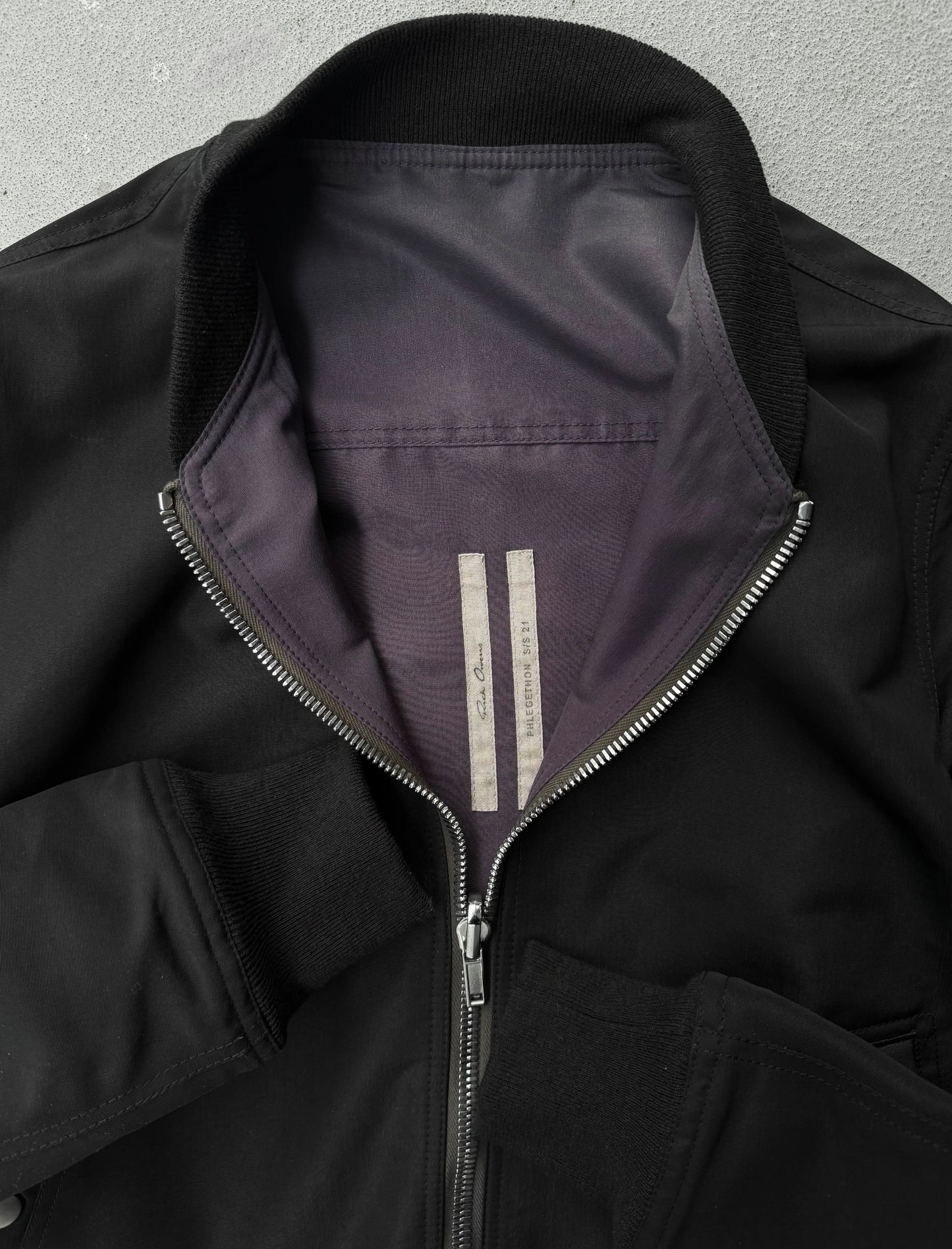 Close-up of a black jacket with a zipper on a gray background