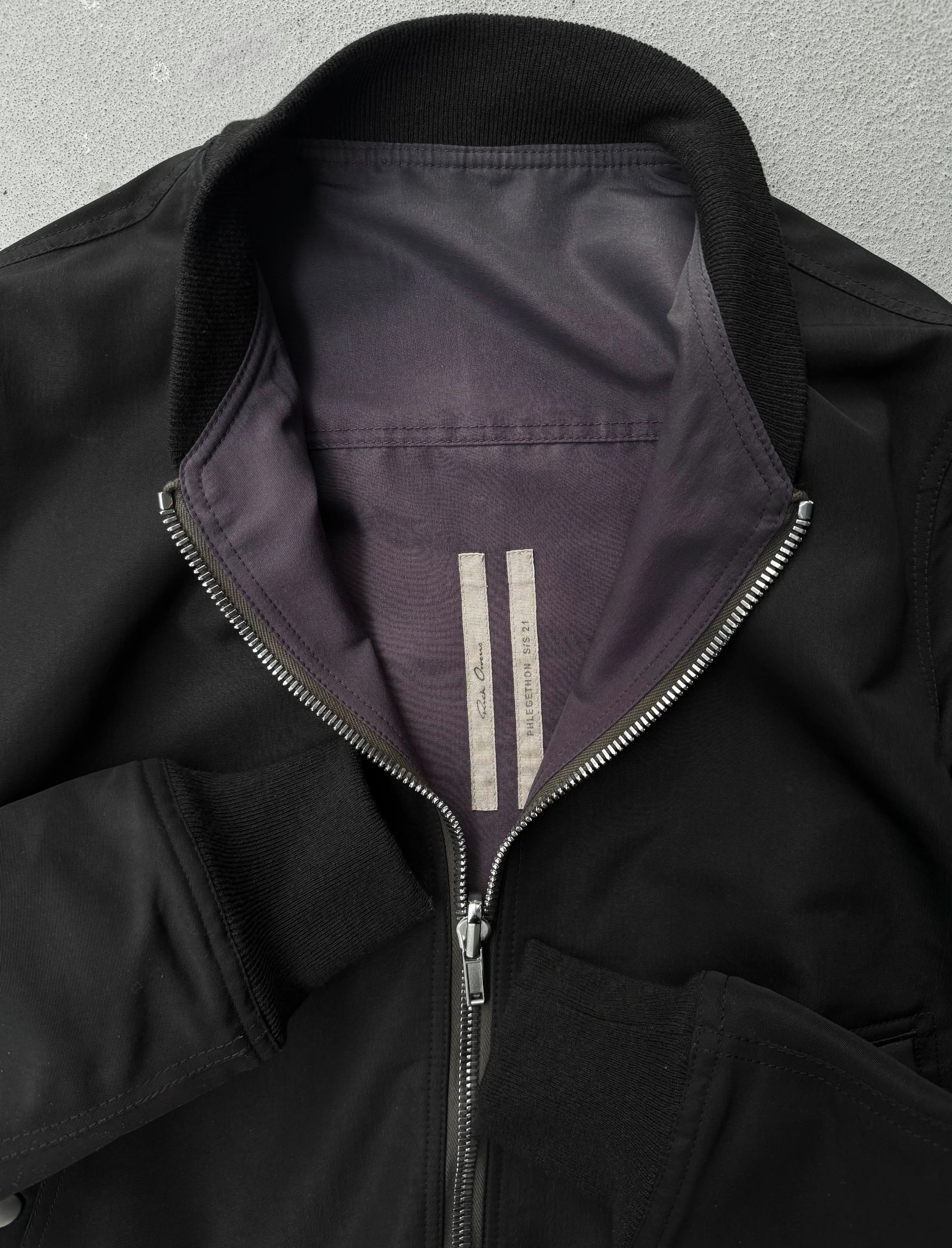 Close-up of a black jacket with a zipper on a gray background