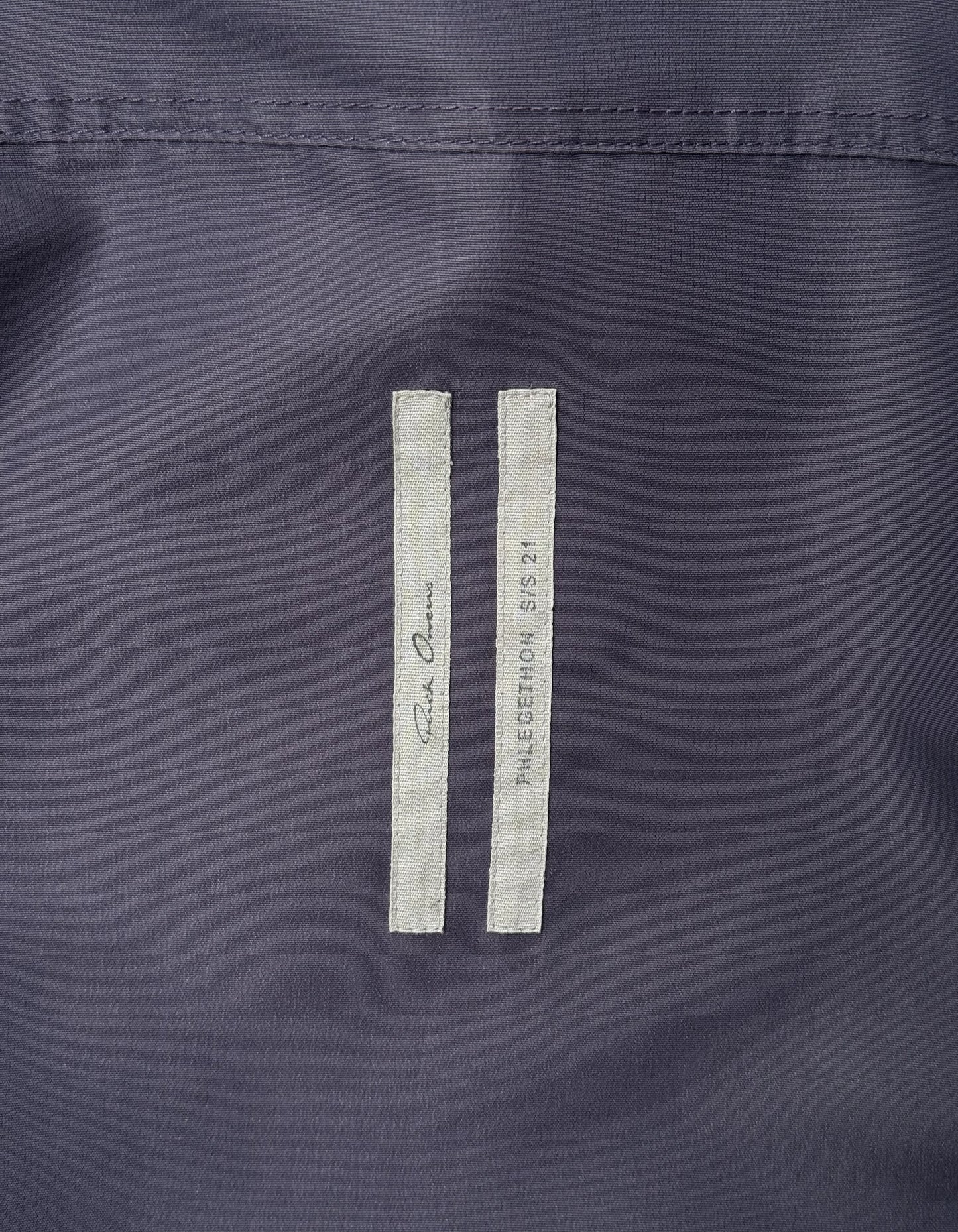 Close-up of a navy blue fabric with a label on a dark background