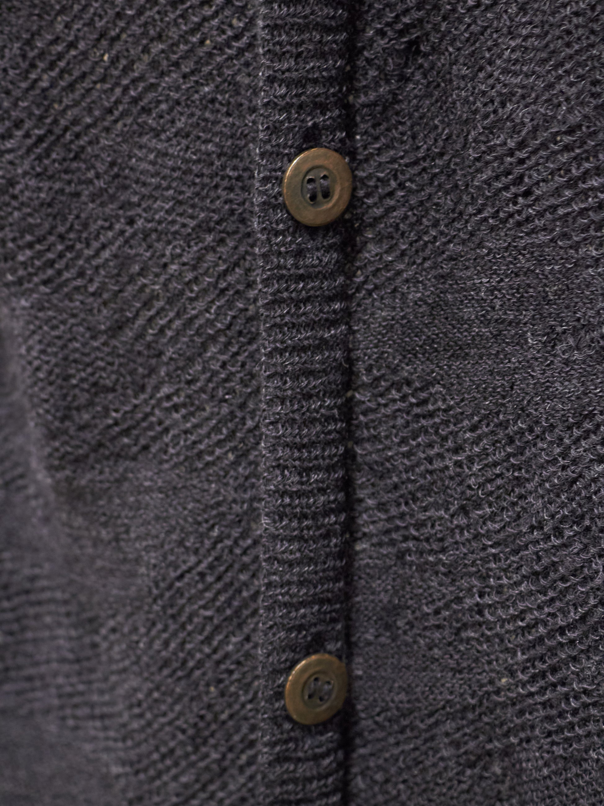Close-up of a textured dark gray fabric with button details