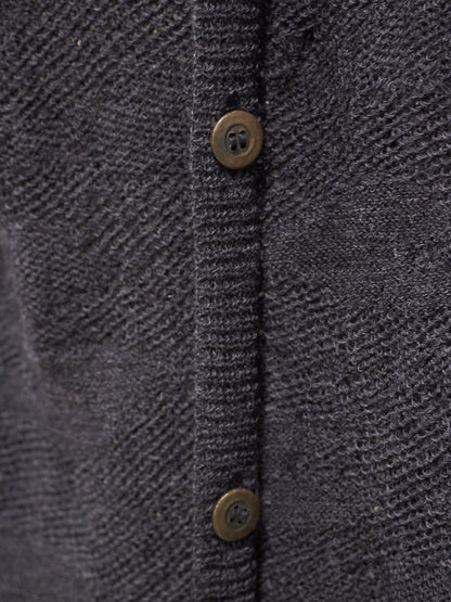 Close-up of a textured dark gray fabric with button details
