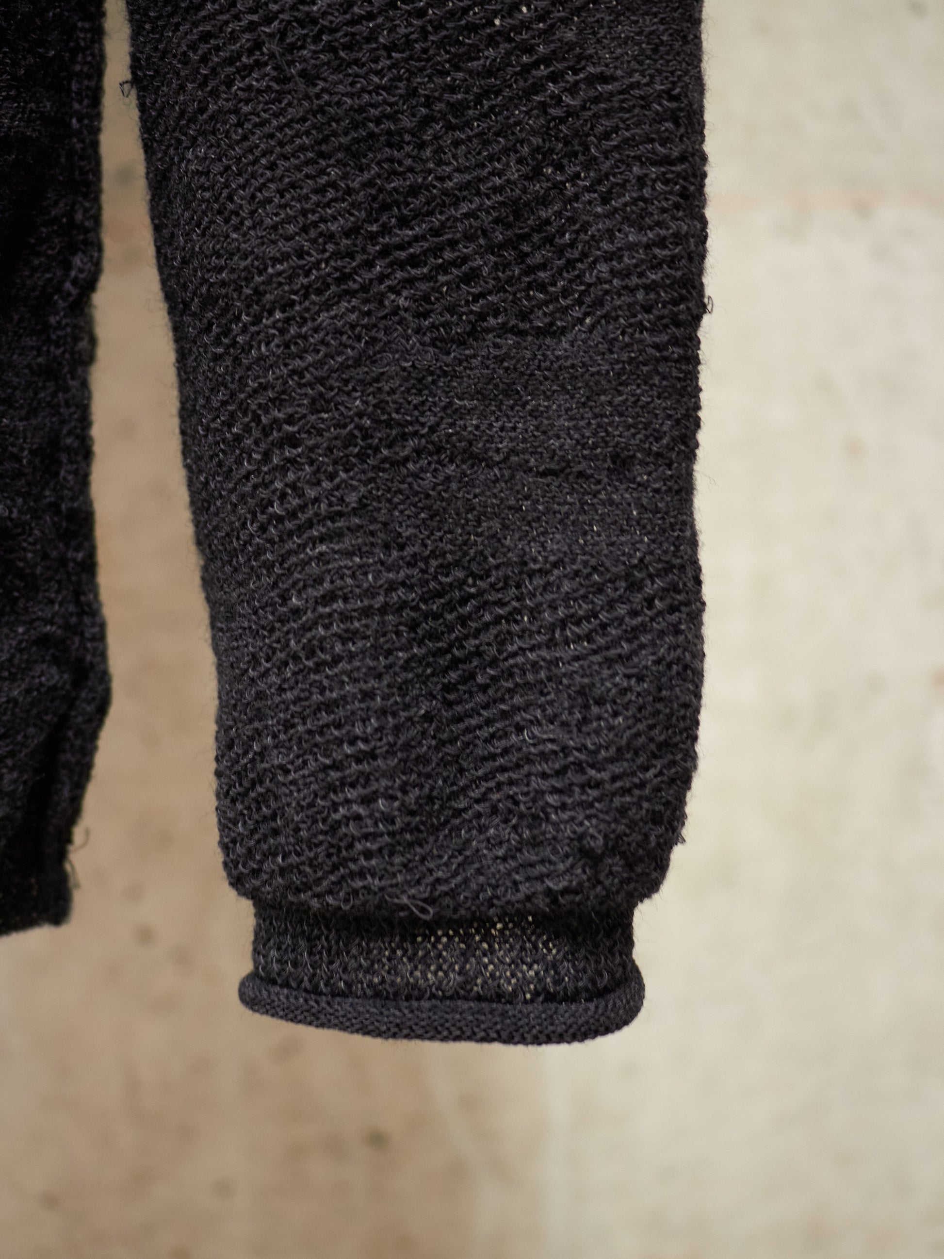Close-up of a textured black sleeve on a light brown background