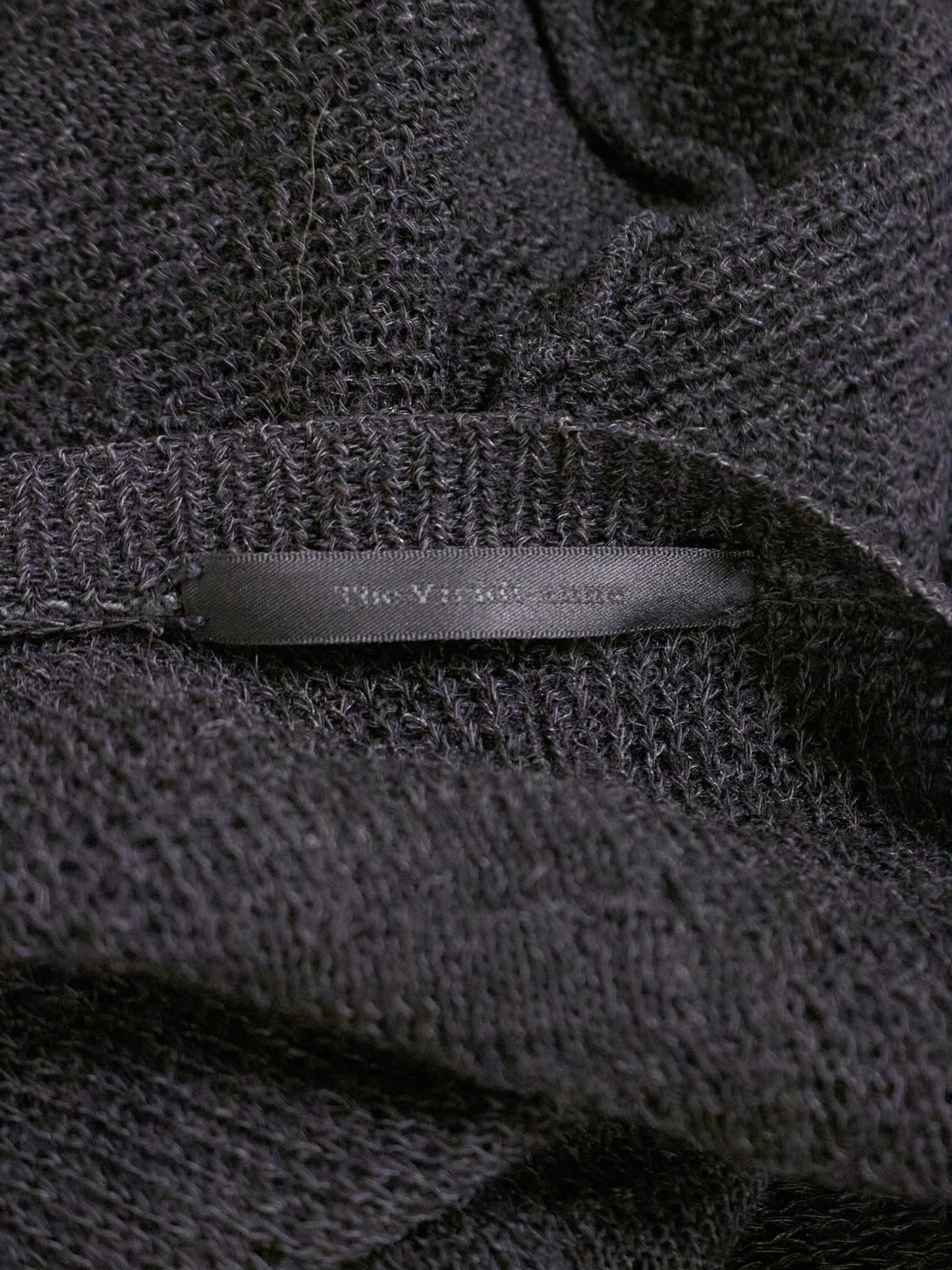 Close-up of a textured dark fabric with a brand label.
