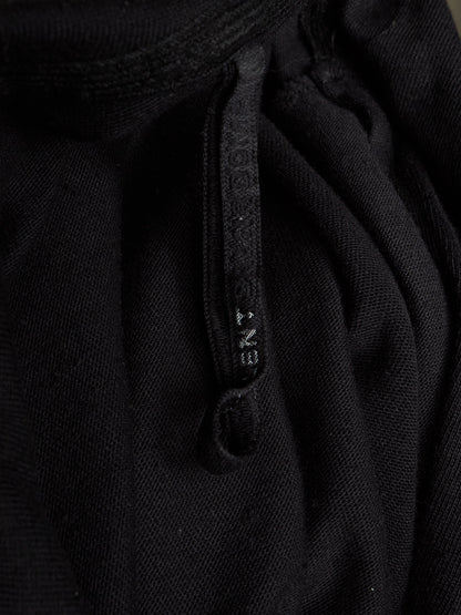 Close-up of a black textured knit garment with a matching black drawstring and a small white debossed brand name reading 'ENT' on the cord.