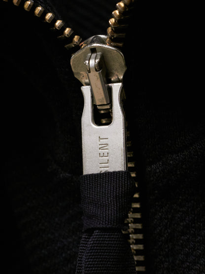 Close-up of a zipper with 'Silent' branding on a black background
