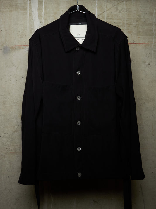 Black jacket on a hanger against a textured wall