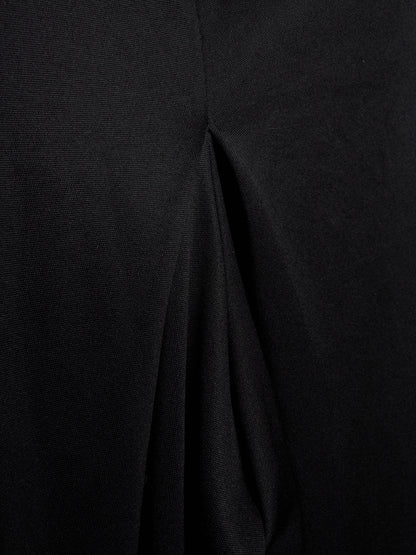 Close-up of a black textured fabric with a central seam and draped folds.