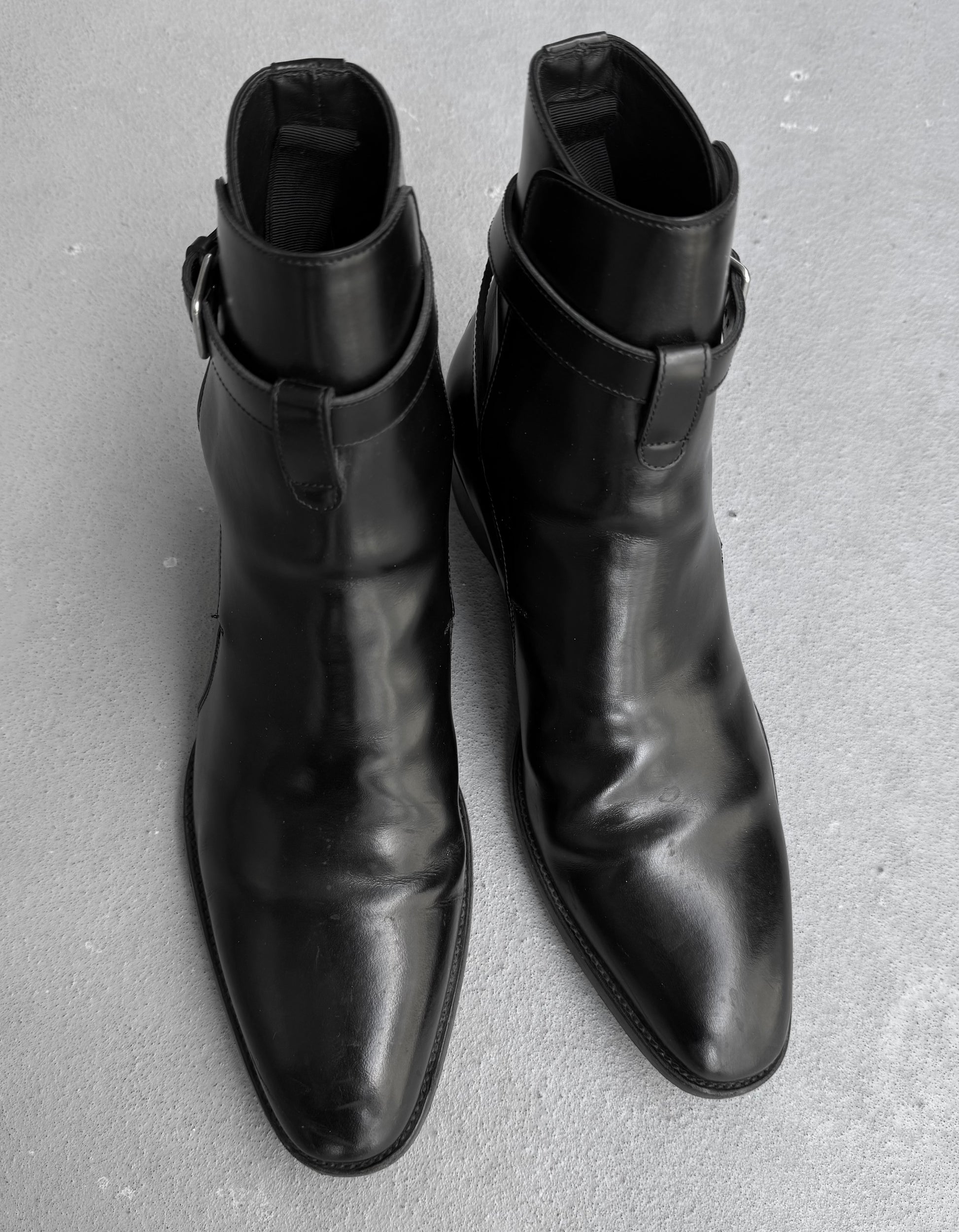Pair of black leather ankle boots on a gray background