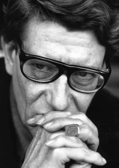 Saint Laurent portrait in black and white — hands over mouth, designer known for sharp tailoring and gritty youth culture