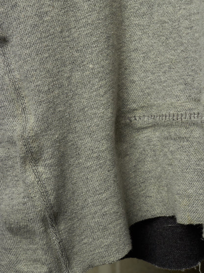 Close-up of a heather gray knit fabric garment, showing the texture and hem detail.