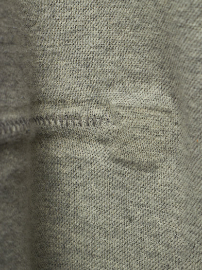 Close-up of a heather gray knit fabric with a visible horizontal seam and slight texture detail.