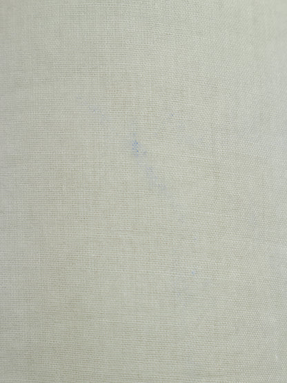 A close-up of a light beige textured fabric with a fine woven linen-like pattern.
