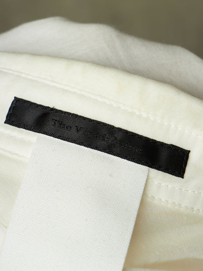 Close-up of a black fabric brand label sewn onto an off-white textile, with the embroidered text 'The Victoria House' visible.