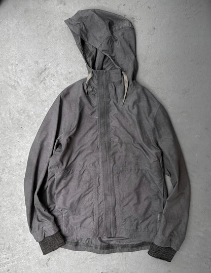 Dark gray hooded jacket on a textured gray surface