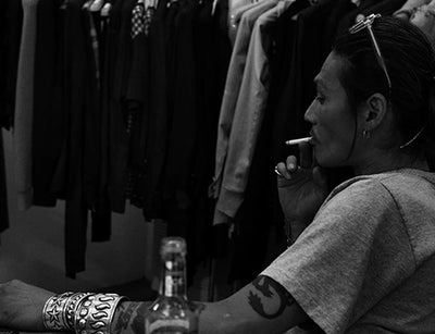 Takahiro Miyashita portrait in black and white smoking — Japanese clothing designer inspired by classic rock and avant-garde 