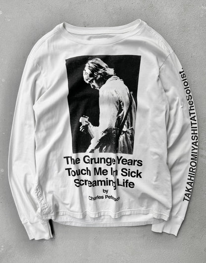 White long-sleeve shirt with graphic design and text on a gray background