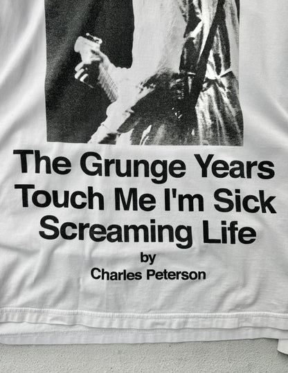 Text on a garment with a black and white photo of a person, featuring the quote 'The Grunge Years Touch Me I'm Sick Screaming Life' by Charles Peterson.