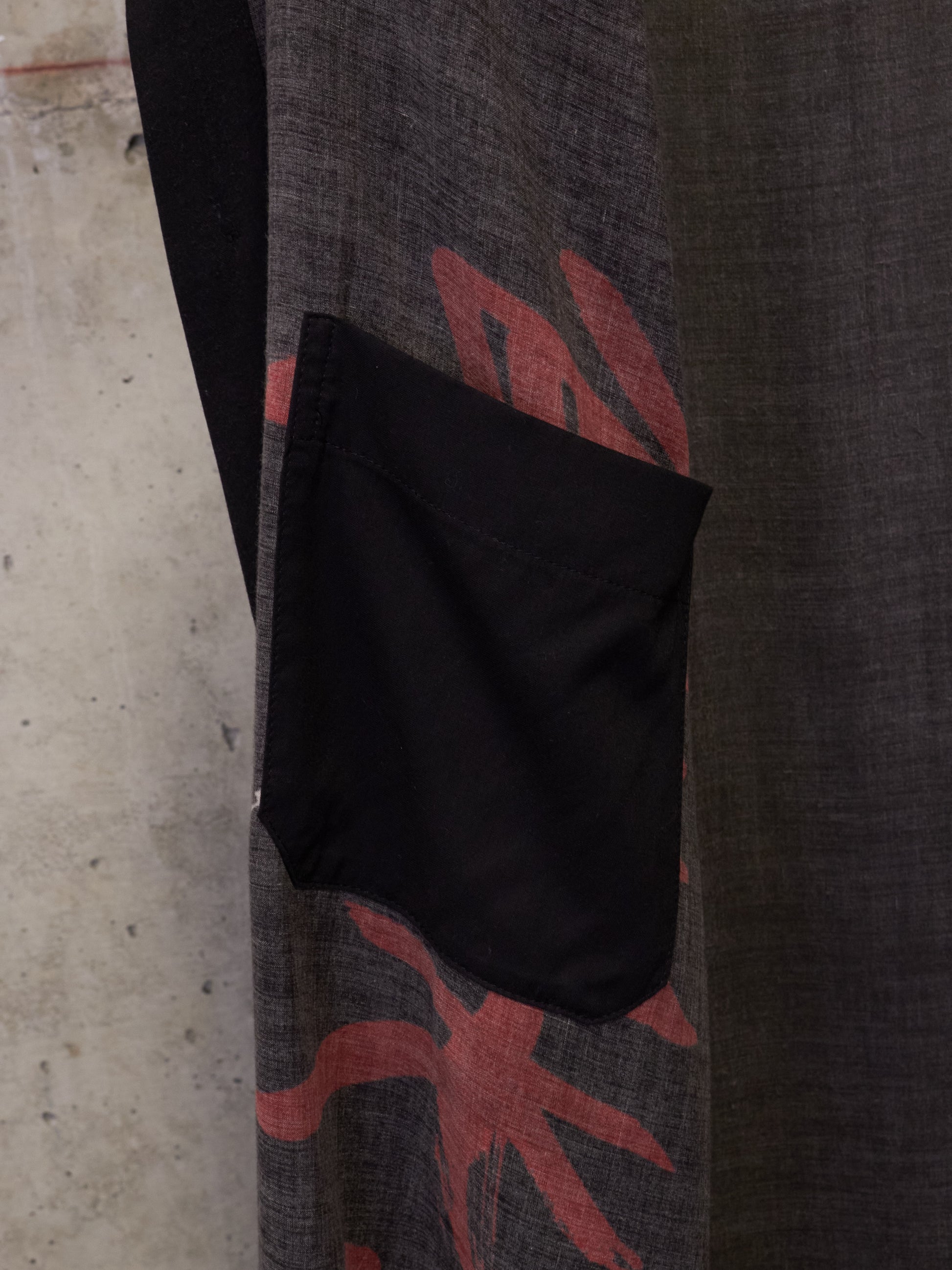 Black bag on a textured surface with red and gray design