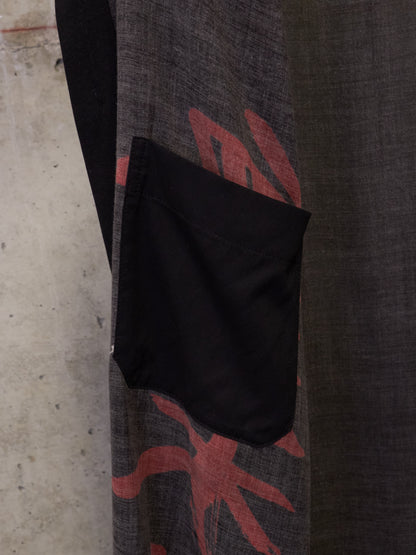 Black bag on a textured surface with red and gray design