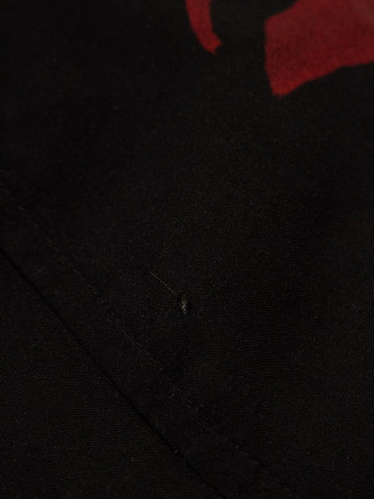 Close-up of a black fabric texture with a red object partially visible.