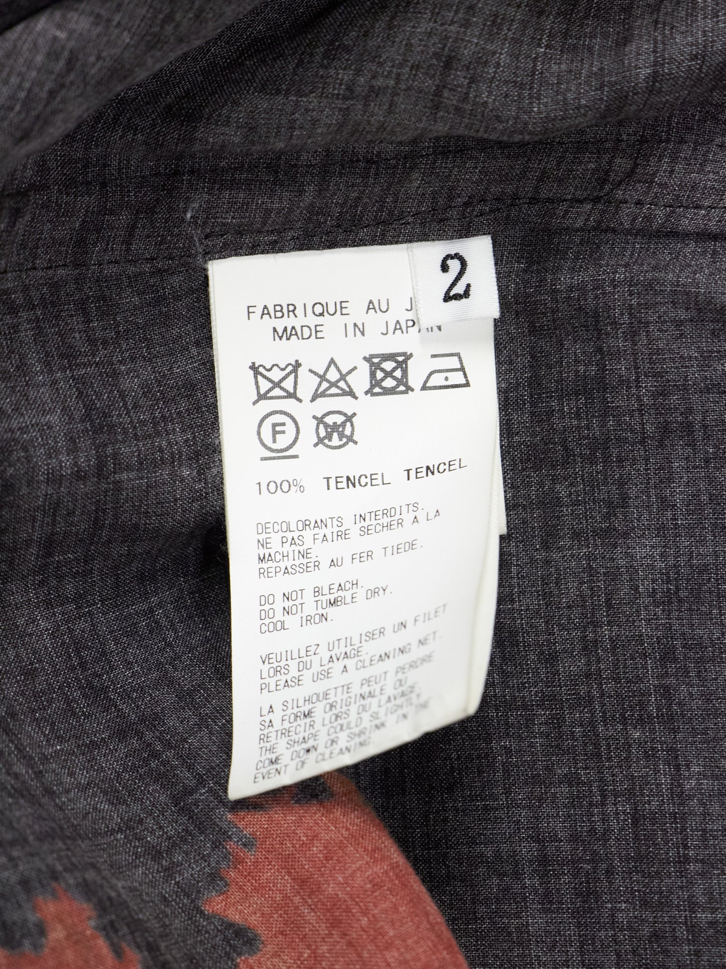 Fabric tag on a garment with text and symbols