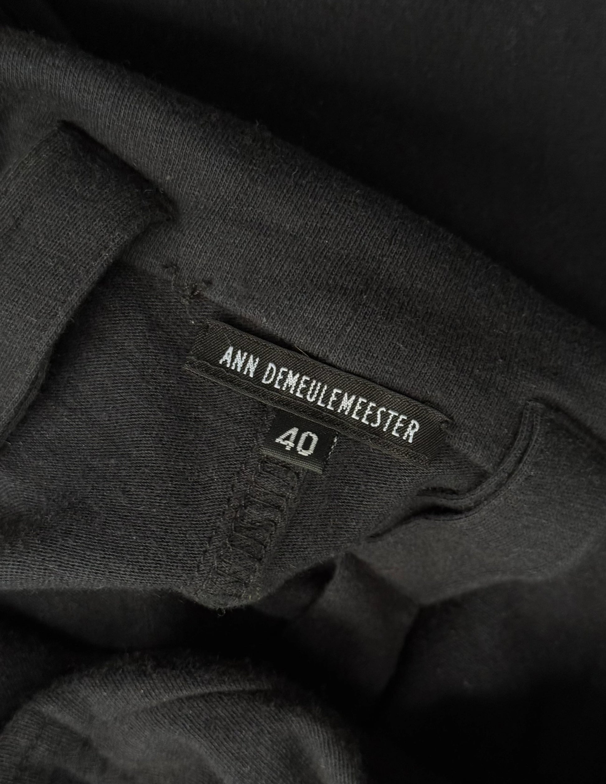 Black clothing with Ann Demeulemeester label and size 40 on a dark background