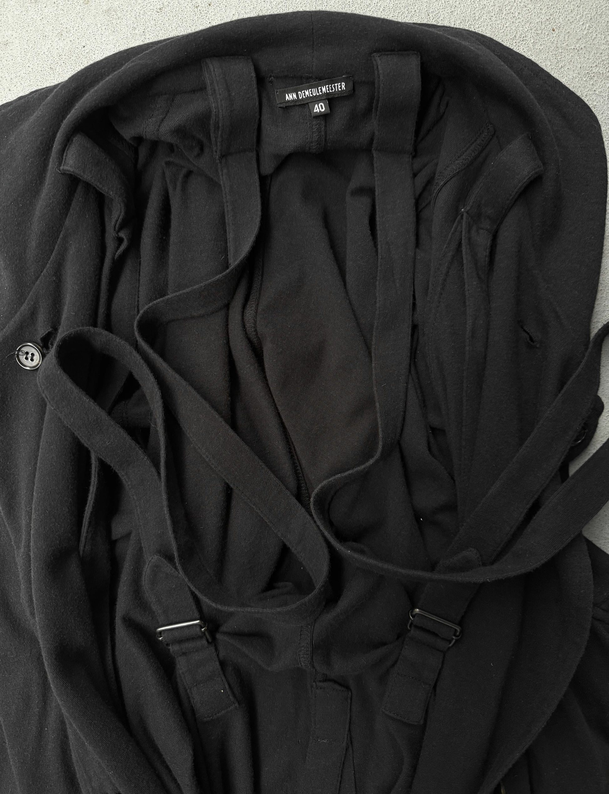 Black jacket with straps on a light gray background