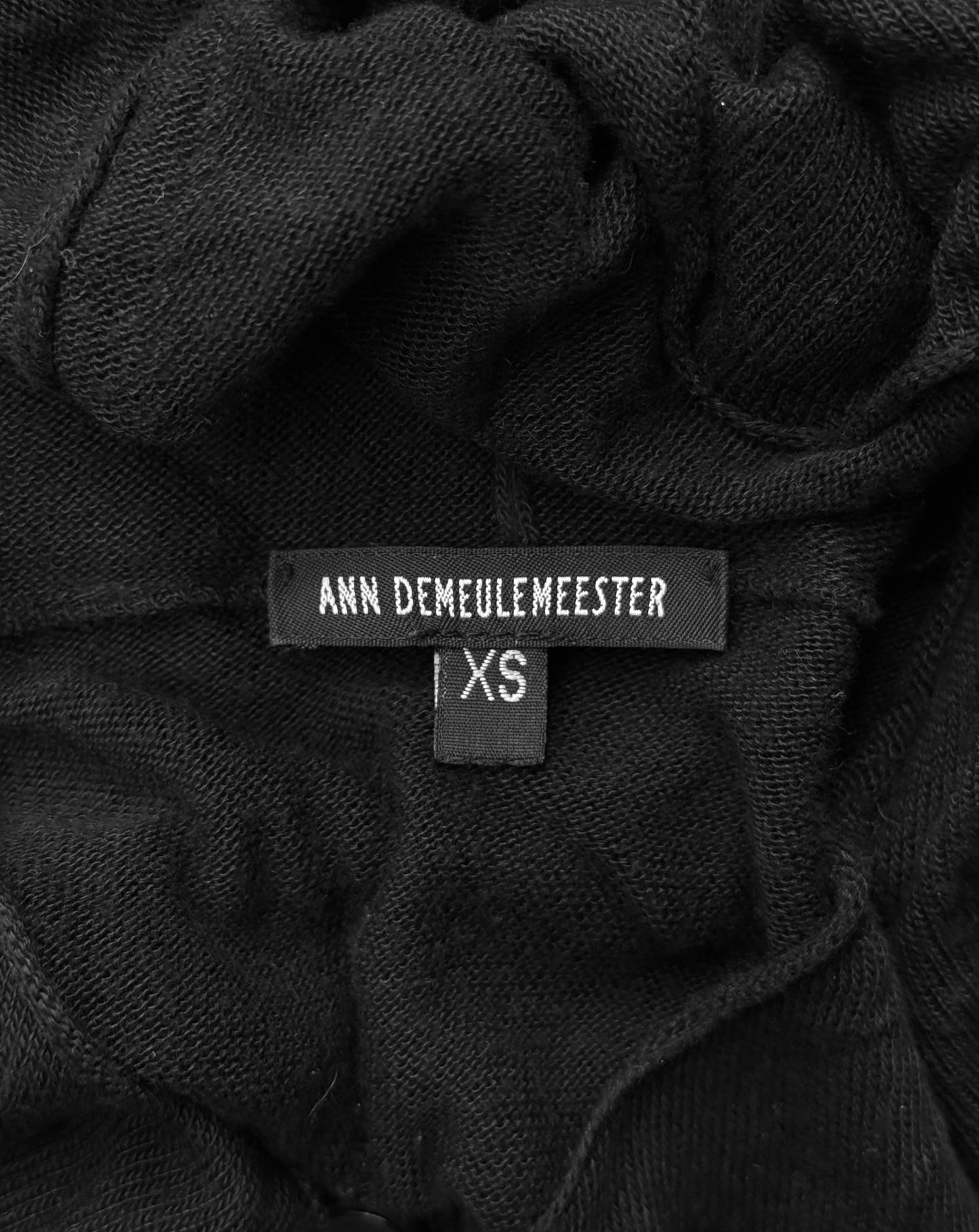 Close-up of a black garment with 'Ann Demeulemeester' label and size tag.