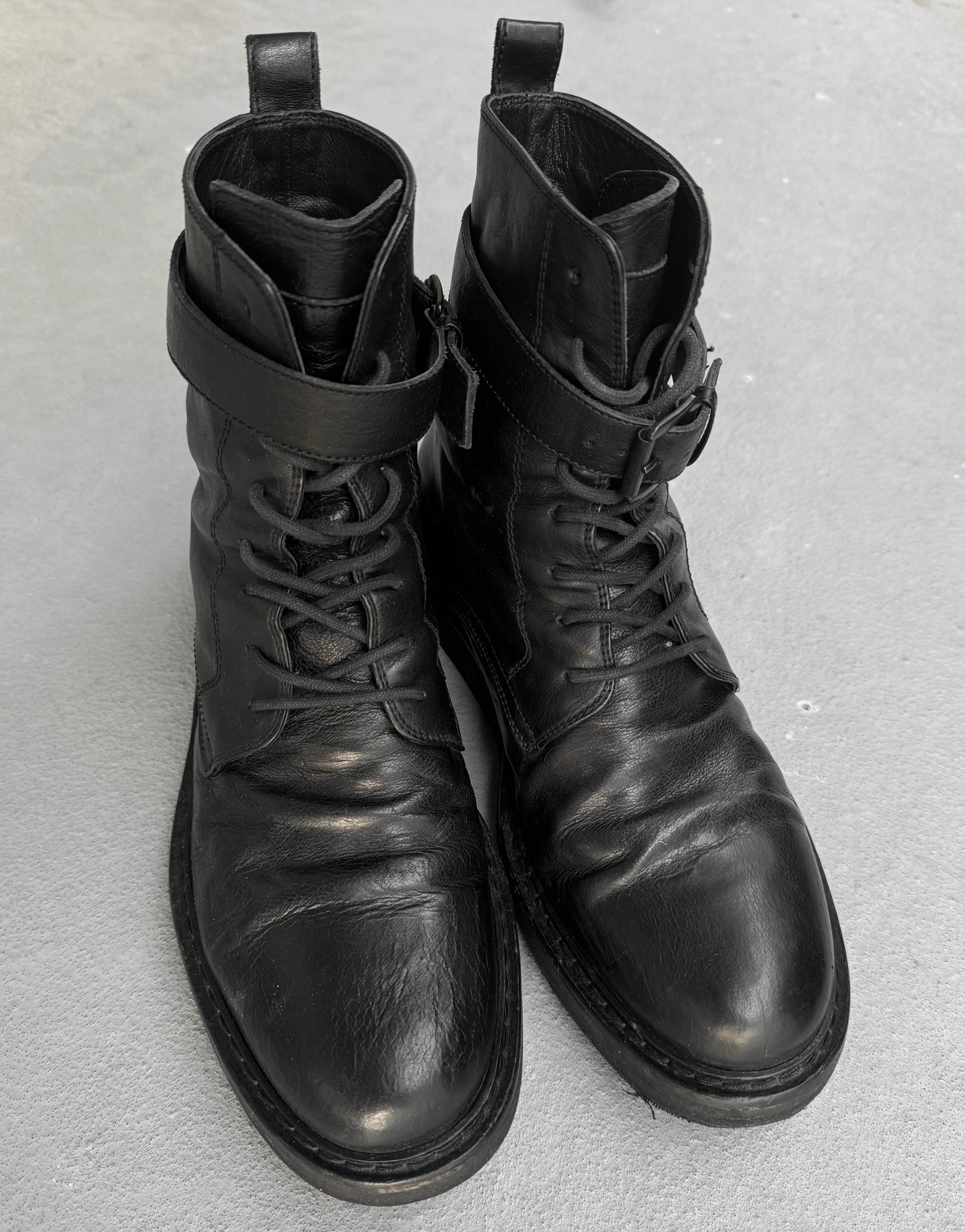 Pair of black leather boots on a gray background