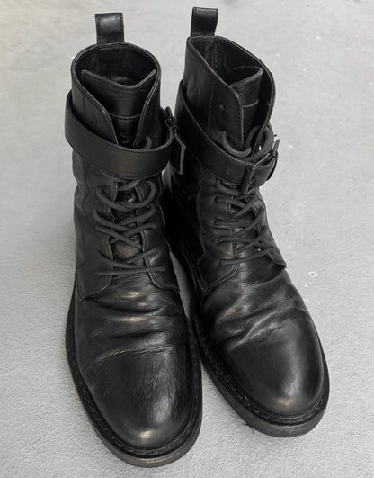 Pair of black leather boots on a gray background