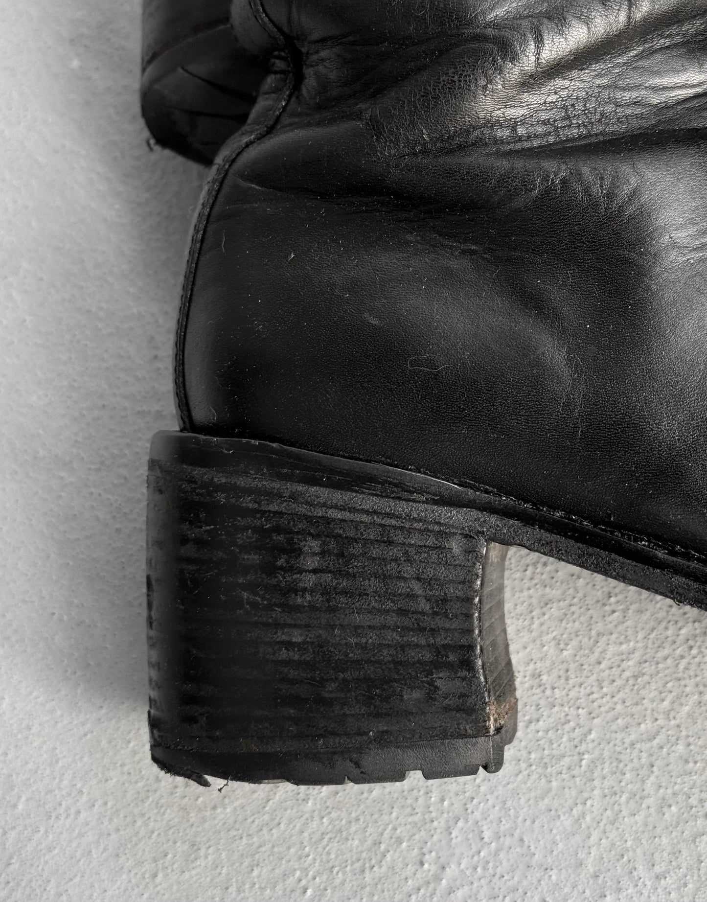 Close-up of a black leather boot sole on a light gray background