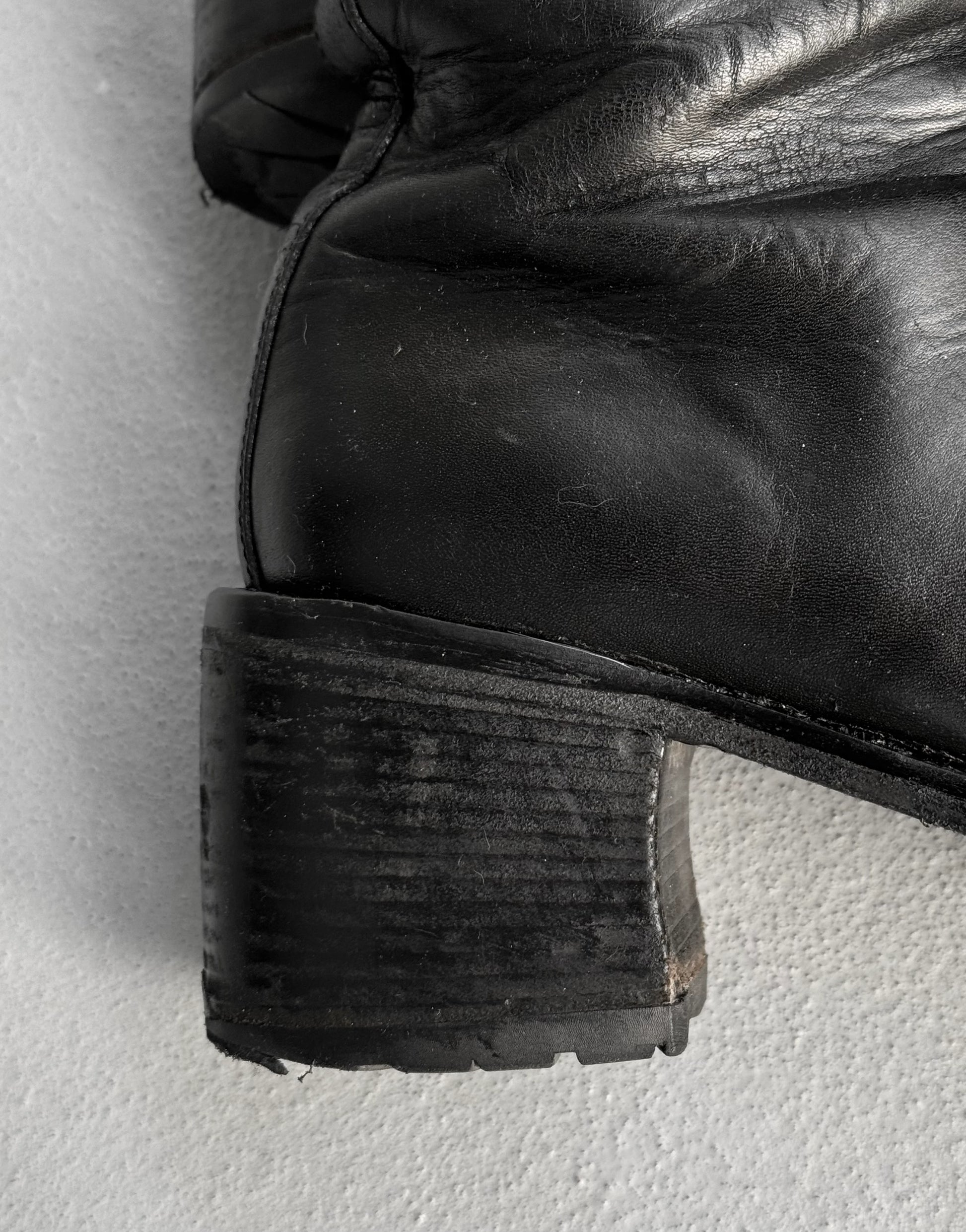 Close-up of a black leather boot sole on a light gray background