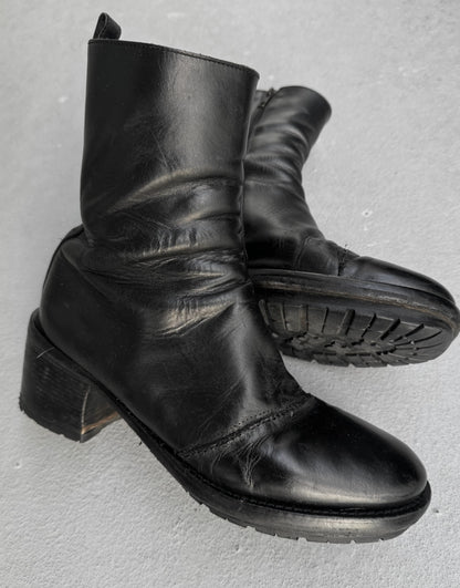 Pair of black leather boots on a gray background